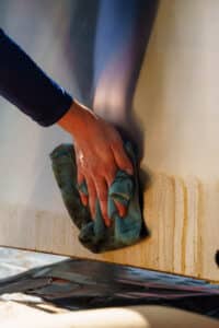 A firemetal employee deep cleaning a grill